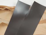 deux morceaux de papier noir posés sur un morceau de papier brun