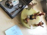 une petite figurine posée sur une table, à côté d'un téléphone portable