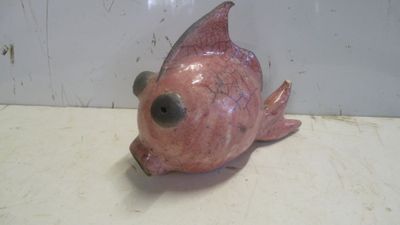 une figurine de poisson rose posée sur un comptoir