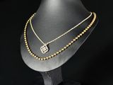 a close up of a necklace on a mannequin on a black background