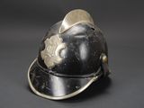 an old fireman ' s helmet with a badge on it
