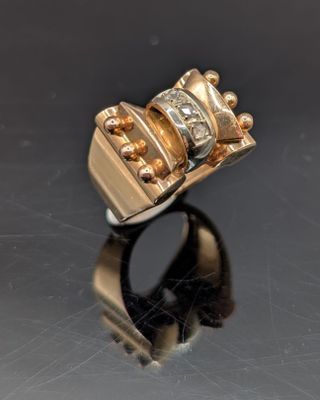 gros plan d'une bague en or surmontée d'un diamant