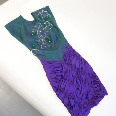 purple and green dress on a white surface