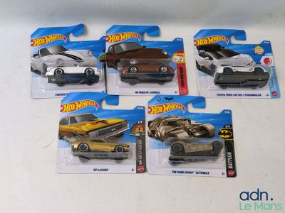 five hot wheels cars that are on display on the table