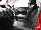 the interior of a red car with black seats and a steering wheel