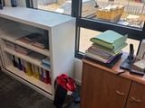 un bureau avec une bibliothèque et une chaise devant une fenêtre