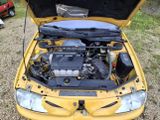 a yellow car with its hood open and the engine in it
