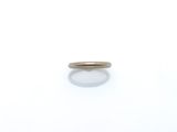 gros plan d'une bague en or sur une surface blanche