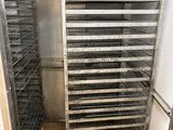 a metal rack with many trays of food inside of it