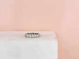 a white diamond ring sitting on top of a white marble block