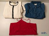 deux chemises et un pull sont posés sur une table