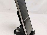a close up of a cell phone on a stand on a white surface