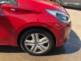 a red car parked in a parking lot with other cars in the background