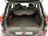 the back of a silver car with the trunk open and the back seats down