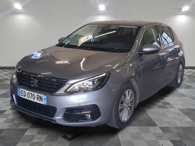 the grey car is parked in the showroom on the checkered floor