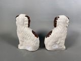pair of white and brown dog figurines on grey background