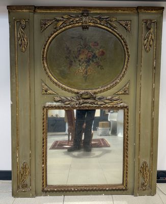un grand miroir orné d'une peinture, placé au milieu d'une pièce
