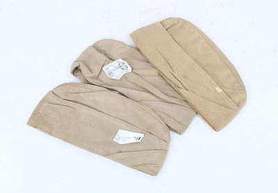 une paire de moufles pour bébé de couleur beige sur fond blanc, avec une étiquette