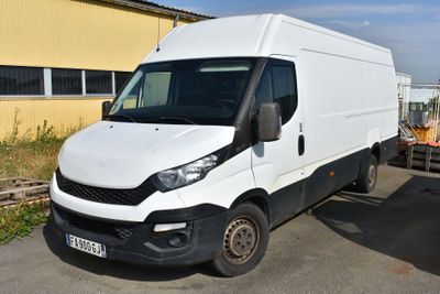 une camionnette blanche garée devant un immeuble jaune