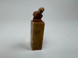 a small statue of a bird on top of a wooden block