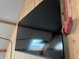 a flat screen tv hanging on a wall in a room