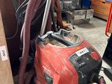 a red vacuum cleaner that is sitting on the floor
