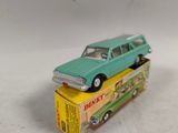 une petite voiture verte posée sur une boîte jaune