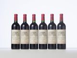 four bottles of red wine lined up in a row
