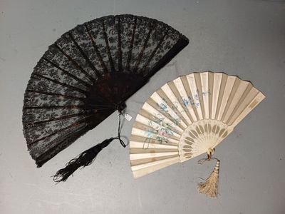 un éventail en dentelle noire et un autre éventail en dentelle noire posés sur une table