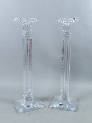 une paire de bougeoirs en verre transparent posés sur une table