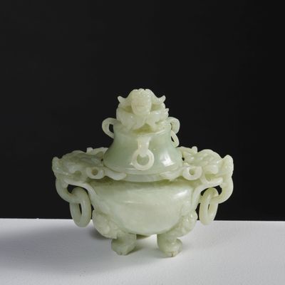 une photo d'un vase vert muni d'un couvercle, posé sur une table blanche