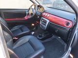 the interior of a small car with red trims and black seats
