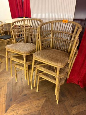 quatre chaises en osier et une table dans une pièce avec un rideau rouge