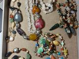 une boîte remplie de bijoux variés et une paire de ciseaux