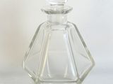 une bouteille en verre transparent ornée d'un motif en forme de losange