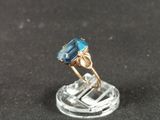 an image of a ring with a blue stone on a clear base
