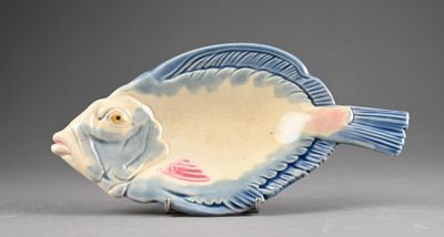 a blue and white fish shaped bowl on a gray surface