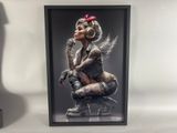 a framed photograph of a woman sitting on top of a chair