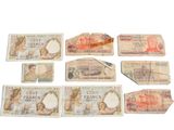 many different types of paper money on a white surface