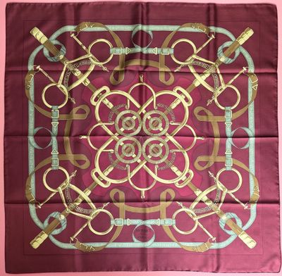 a square scarf with a gold and blue design on it