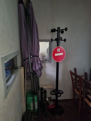 a room with a table, chairs, and a sign on the wall