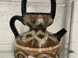 un vase muni d'une anse, exposé dans une vitrine