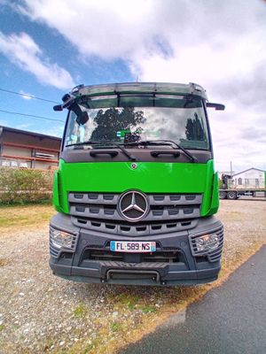 un camion vert garé sur le bord de la route