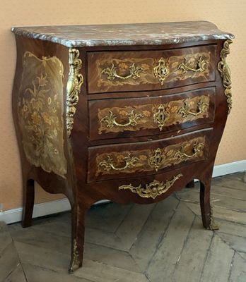 a small chest of drawers with a marble top