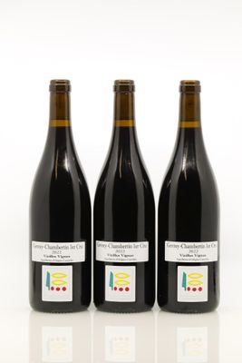 trois bouteilles de vin posées les unes à côté des autres sur une surface blanche