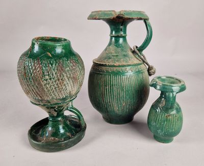 three green vases sitting next to each other on a table