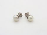 a pair of pearl earrings on a white surface