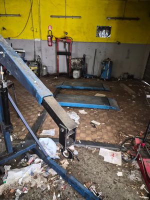 an image of a garage with a crane in the middle of the floor