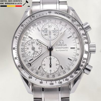 un gros plan d'une montre argentée sur fond blanc