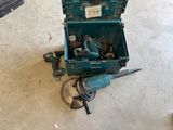 a green tool box with tools in it on the floor
